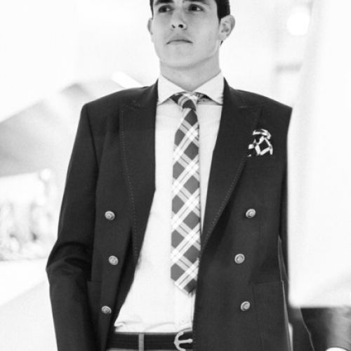 Imagen en blanco y negro de chico con traje y corbata de cuadros