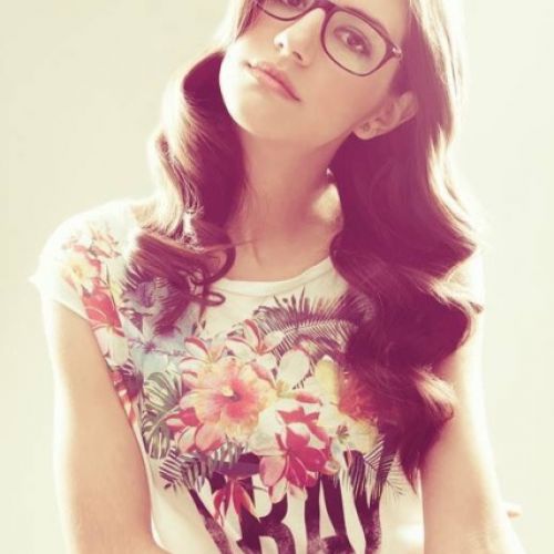 Imagen en de chica con pelo largo ondulado con camiseta de flores y gafas